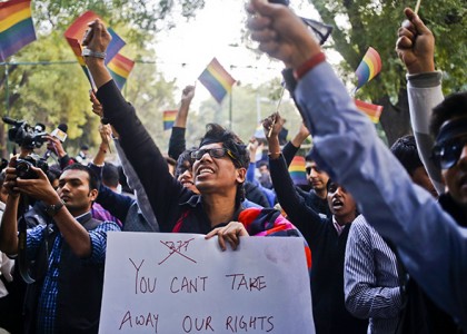 Gay rights activists wave flags and shout slogans as they attend protest against a verdict by the Supreme Court in New Delhi