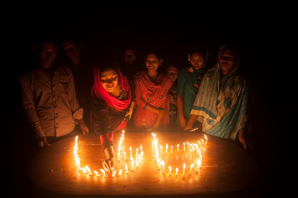 A woman from a enclave lit candles as she take part in the celebration at Dasiarchhara, Kurigram, Bangladesh, Aug 01, 2015.