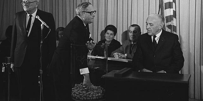  [Congressman Alexander Pirnie reaching into a container of draft numbers (center) as others look on, including retiring Selective Service Director Lt. General Lewis Blaine Hershey (left) and Deputy Director Col. Daniel O. Omer (right) at the Selective Service Headquarters during the nationwide draft lottery] / MST.